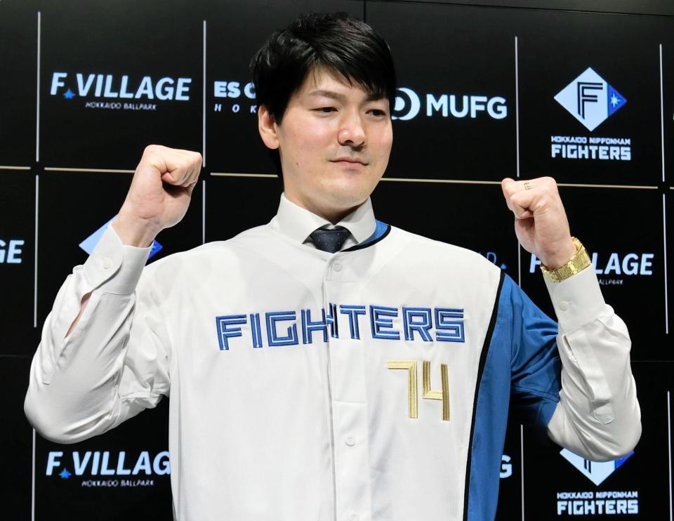 　入団会見に臨み、背番号７４のユニホームを着てポーズをとる有原