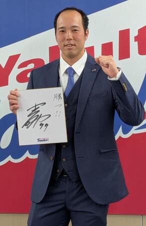 色紙に「勝つ！」としたため、ガッツポーズを見せる青柳