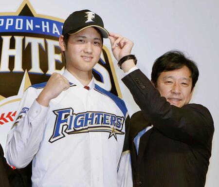 ２０１２年１２月、日本ハムの入団会見で、栗山監督（右）とポーズを取る大谷翔平選手＝札幌市