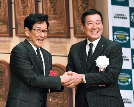 　原氏（右）から祝福され、笑顔を見せる栗山氏（撮影・佐藤厚）