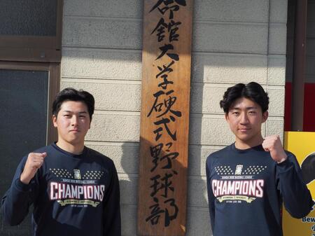 寮の前でポーズする立命大・有馬と西野（右）