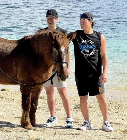 　伊江島ビーチサイドホースパークの馬・ボブ君とふれ合う松本（左）と郡