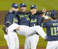 日本一に輝き、村上（左）と山田に担がれて記念撮影するヤクルト・高津監督＝２０２１年１１月