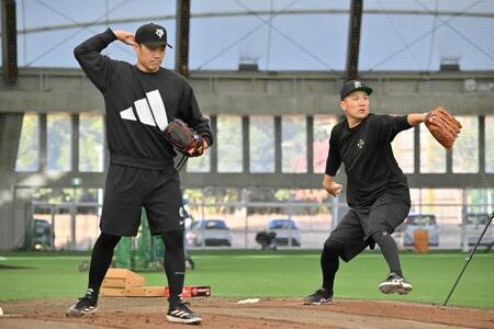 　ブルペンで投げる則本（左）と田中将