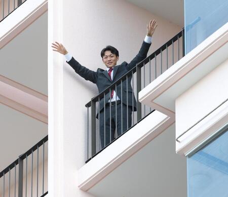 沖縄入りし、ホテルの部屋から両手を振る藤原（撮影・西岡正）