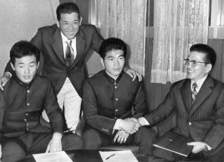 広島へ入団が決まり、木庭教スカウト（右）と握手する崇徳高校・山崎隆造（右から２人目）と小川達明（左）＝１９７６年１２月