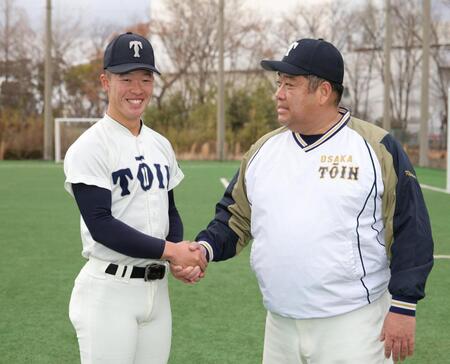 選抜出場が決まり、大阪桐蔭・西谷浩一監督（右）と握手をかわす大阪桐蔭・吉岡貫介（撮影・坂部計介）