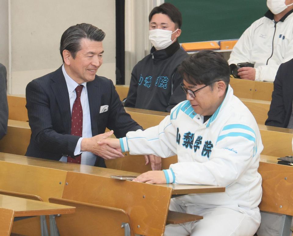 出場を決め、山梨学院・吉田正校長（左）と握手する山梨学院・吉田洸二監督（撮影・石井剣太郎）