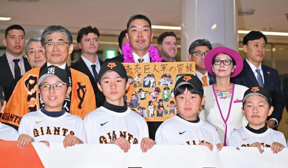 歓迎セレモニーで、記念品を手に写真に納まる阿部監督（中央）