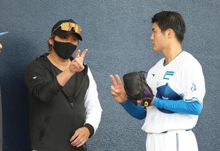 新庄監督（左）からアドバイスを受ける菊地（撮影・西岡正）