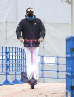 電動キックボードでさっそうと球場入りする新庄監督（撮影・西岡正）