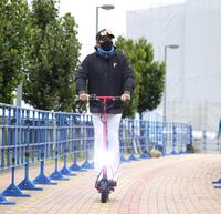 電動キックボードでさっそうと球場入りする新庄監督（撮影・西岡正）