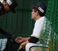 ブルペンで投球後、少し手を気にする九里（右）＝撮影・中田匡峻