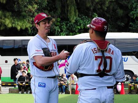 今キャンプ２度目のブルペン入りを終えた前田健（左）は受けた石原と言葉を交わす