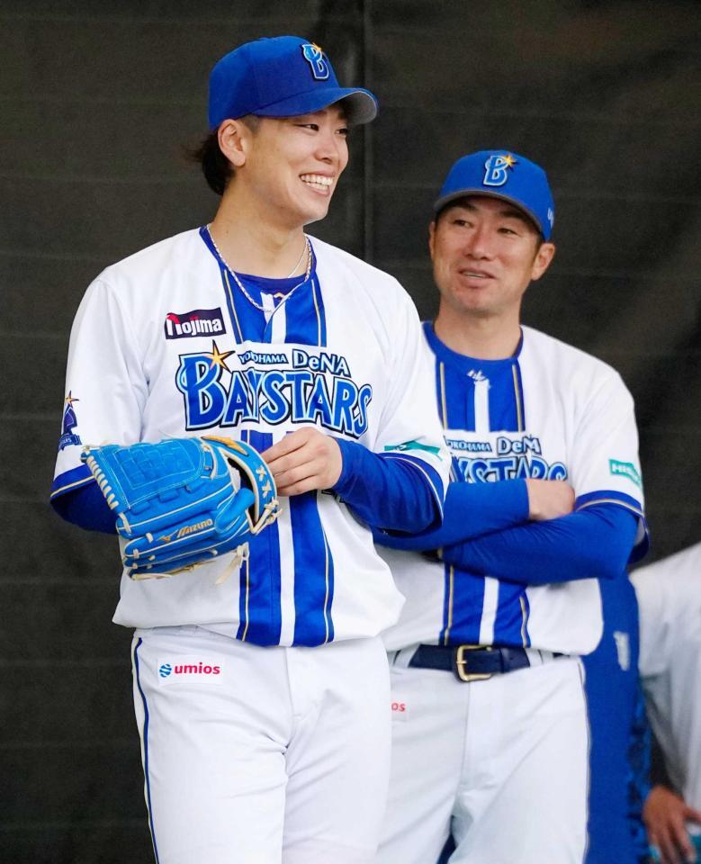 　投球練習中に相川監督（右）から声をかけられ笑顔の入江