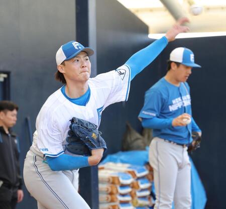 北山（右）の横で投げ込む山崎（撮影・西岡正）