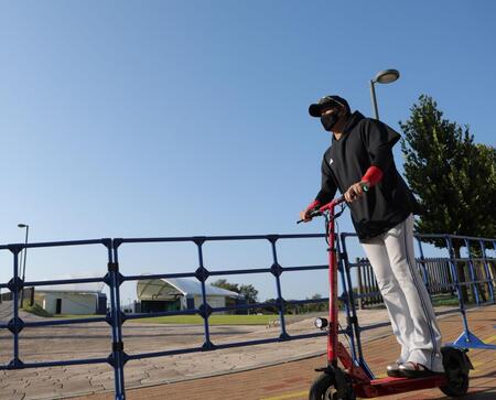 青空の下、電動キックボードで球場入りする新庄監督（撮影・西岡正）