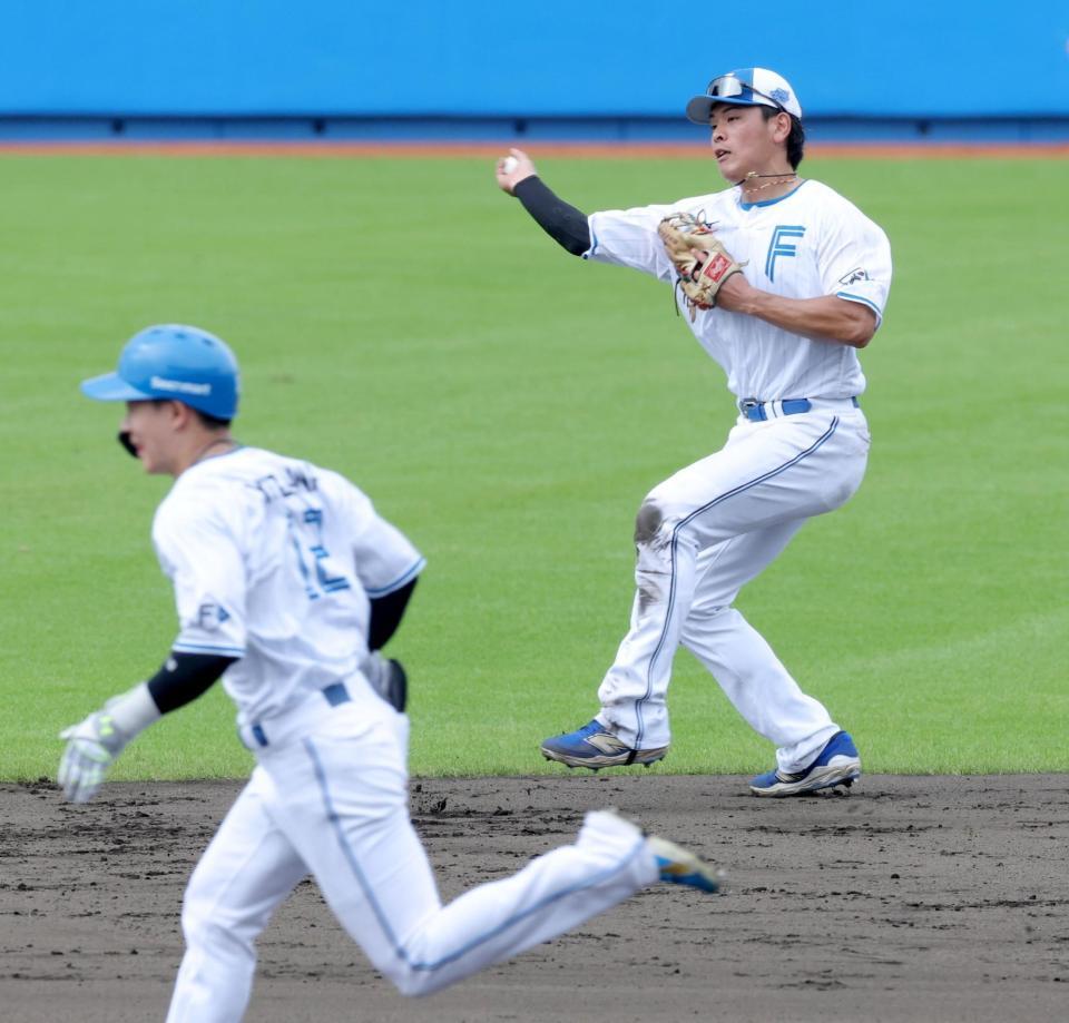 作戦バッティングで二塁の守備をする野村（右）＝撮影・西岡正