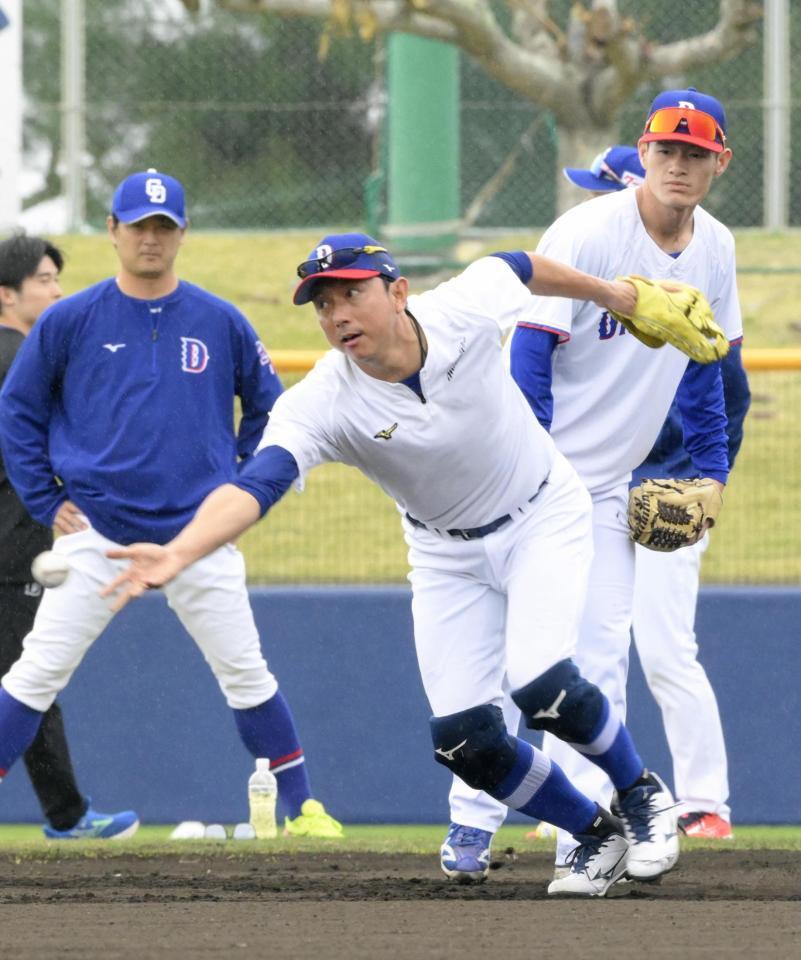 　早出練習で川崎宗則臨時コーチ（手前）の守備を見る新保（右）