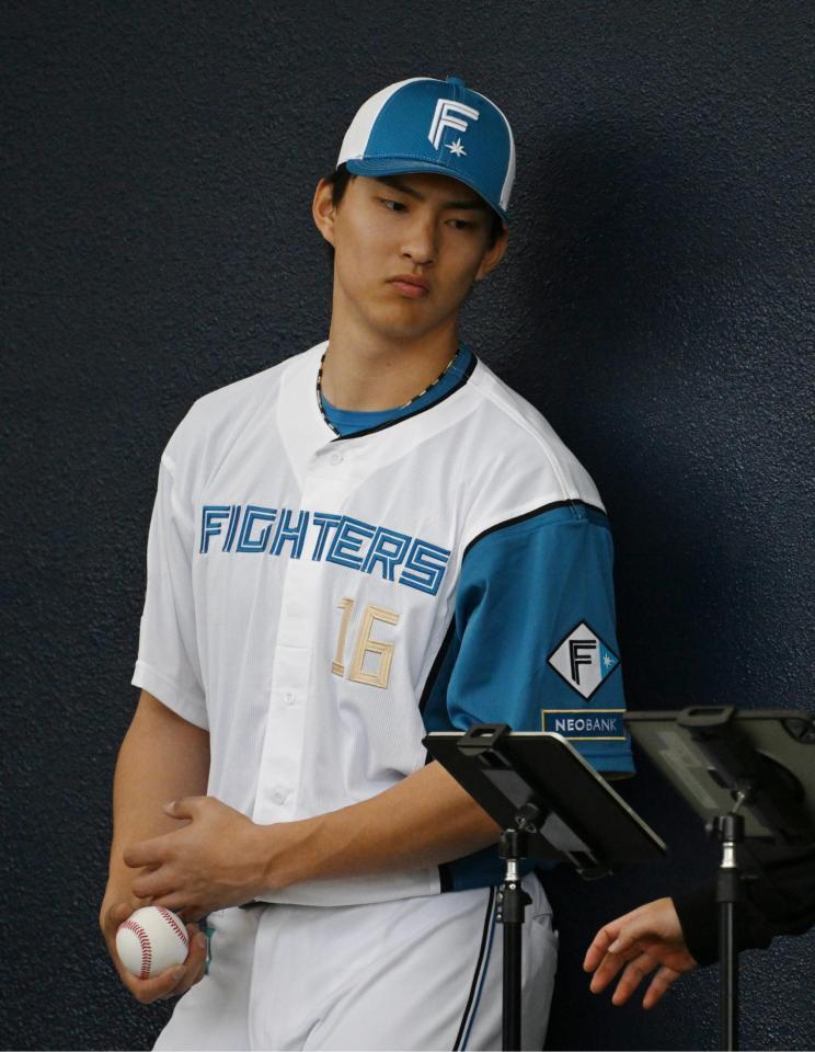 ブルペンで投球データをを確認する達