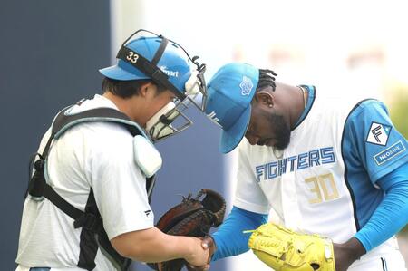 初ブルペンを終え、進藤（左）と握手するラオ（撮影・西岡正）