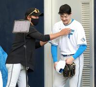 ブルペンでの投球後、新庄監督（左）と話す有原（撮影・西岡正）