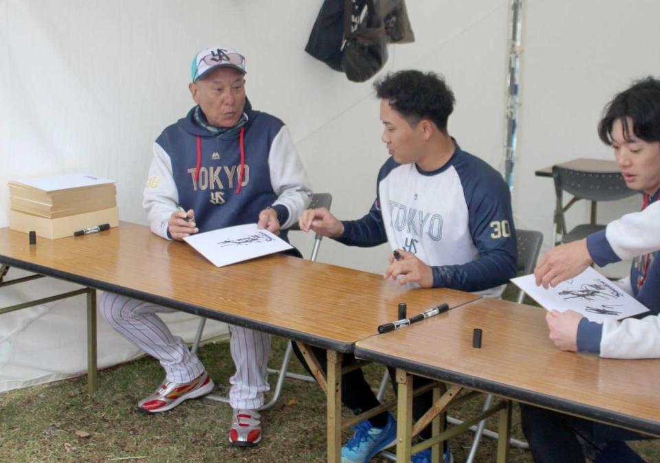 　サインを書く池山監督（左）
