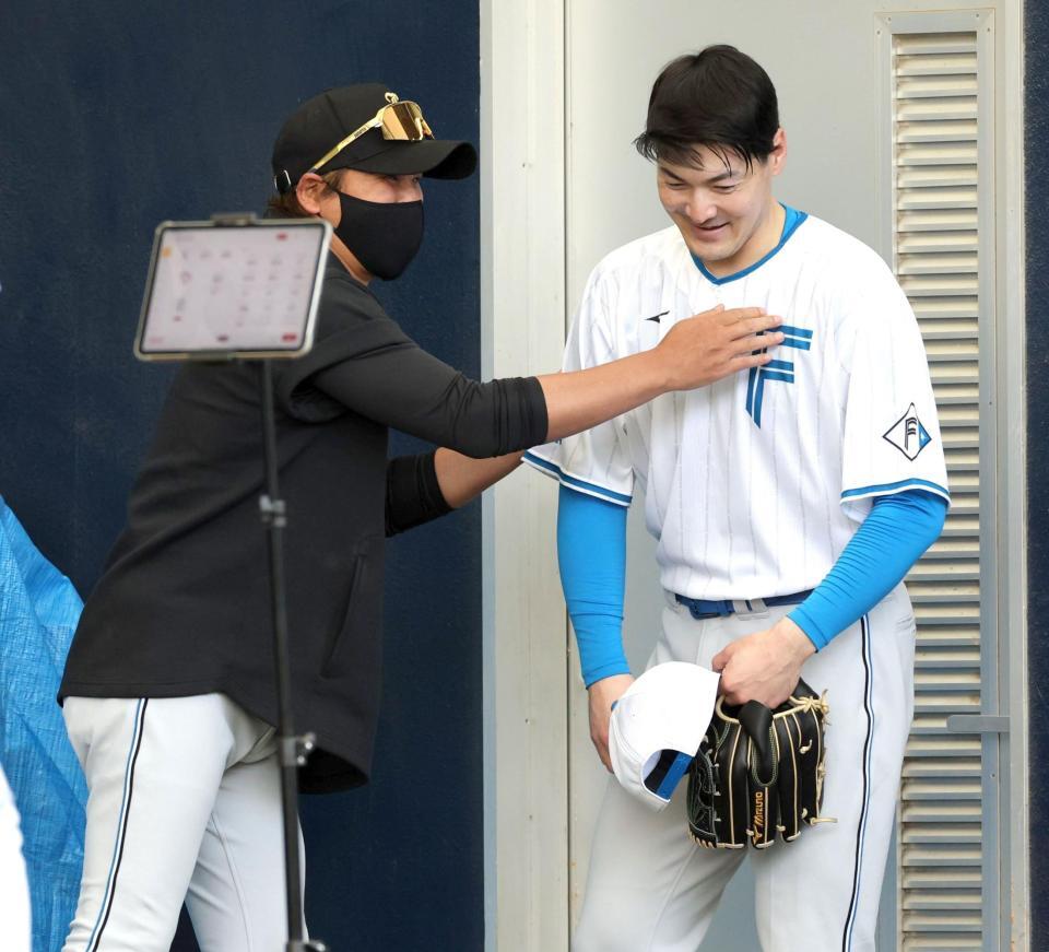 ブルペンでの投球後、新庄監督（左）と話す有原（撮影・西岡正）