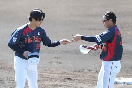 実戦形式の練習中、ピッチコムの不具合で、北山（左）の受信機を交換するサポートメンバーの中山