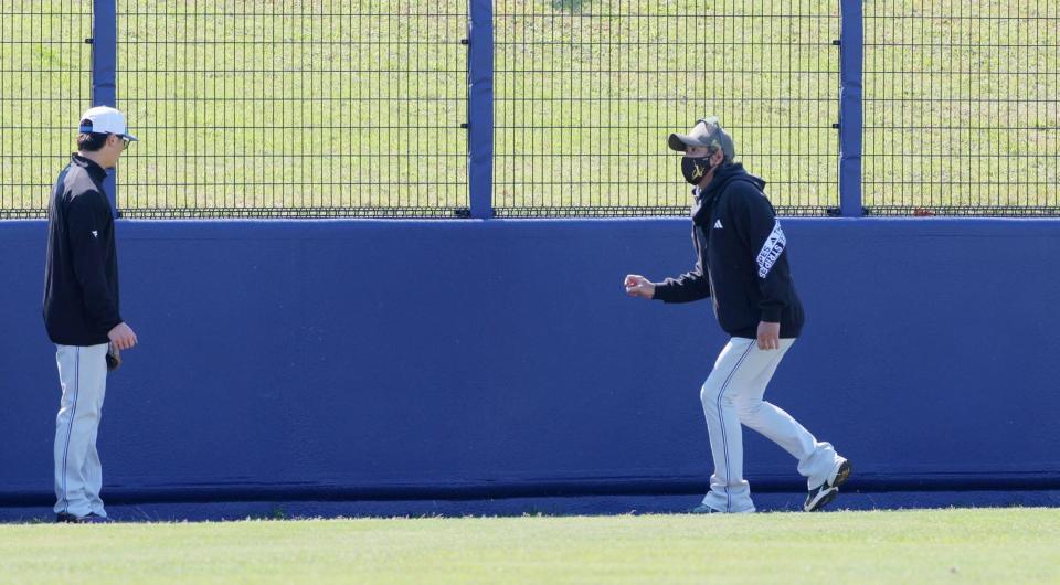 試合前に外野フェンスをチェックする新庄監督（右）＝沖縄・北谷