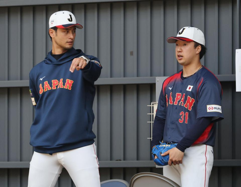 ブルペンでアドバイザーのダルビッシュ（左）からアドバイスを受けるサポートメンバーの佐藤柳