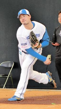 ブルペンで投球練習をする有原