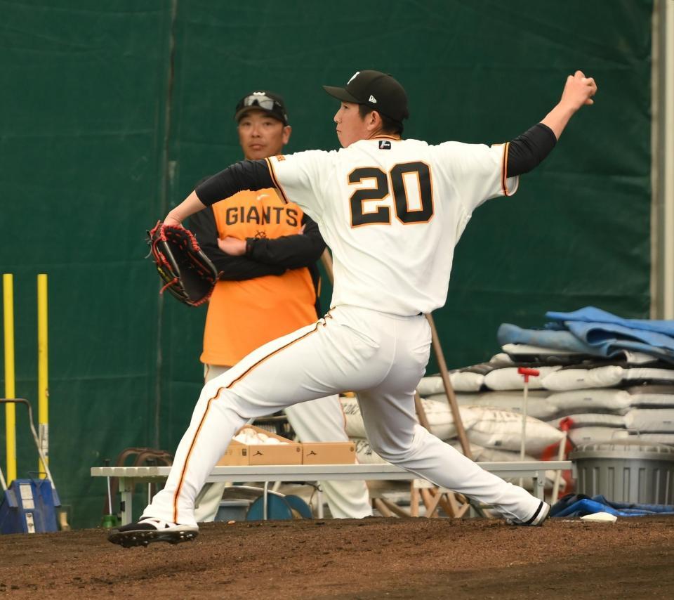 ブルペンでピッチングをする戸郷。後方は阿部監督（撮影・開出牧）