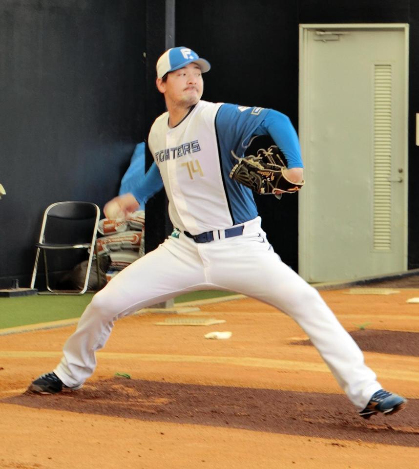 ブルペンで投球練習をする有原