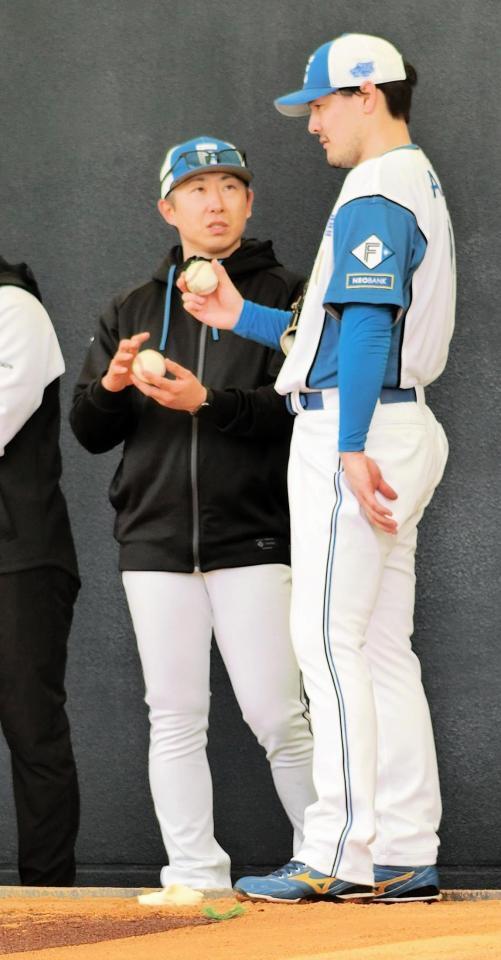 有原（右）はブルペンで金子投手コーディネーターと話す
