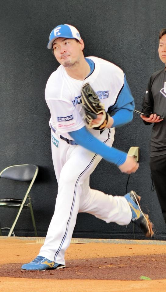 ブルペンで投球練習をする有原