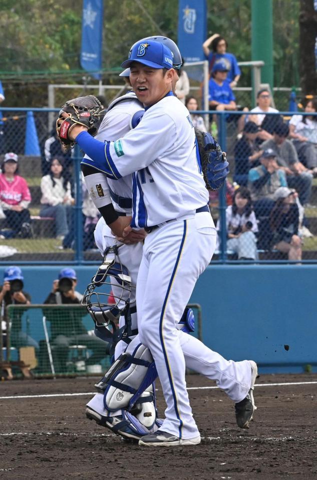 無失点で抑えきり戸柱と抱き合う山崎（右）＝撮影・持木克友