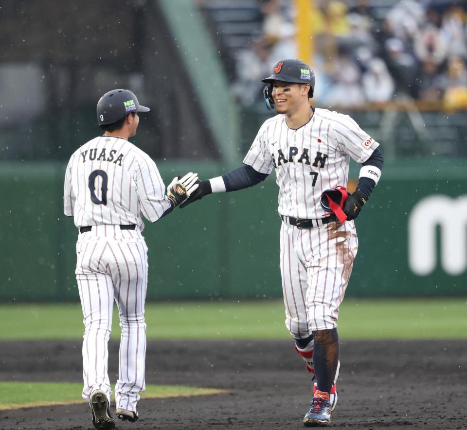 二塁打を放ち、代走の湯浅（左）と笑顔でハイタッチする佐藤輝（撮影・伊藤笙子）