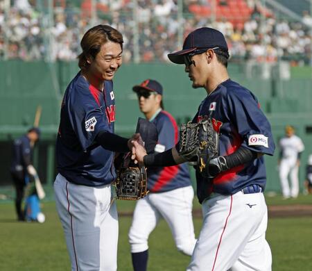 　５回を投げ終え、好捕を見せた牧原大（右）とタッチを交わす高橋宏