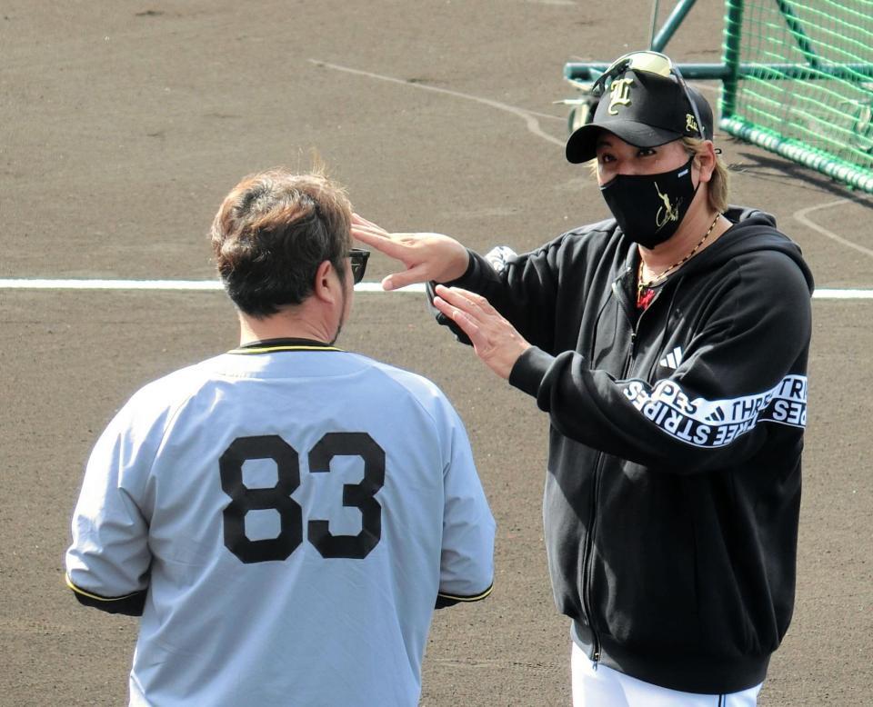 小谷野打撃チーフコーチ（背中）と話す新庄監督