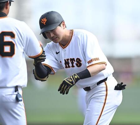 ４回、左前打を放ち吉川コーチ（手前）とタッチを交わす泉口（撮影・開出牧）