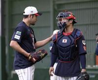 ブルペンでの投球を終え、坂本（右）の肩をポンとたたく菊池（撮影・伊藤笙子）