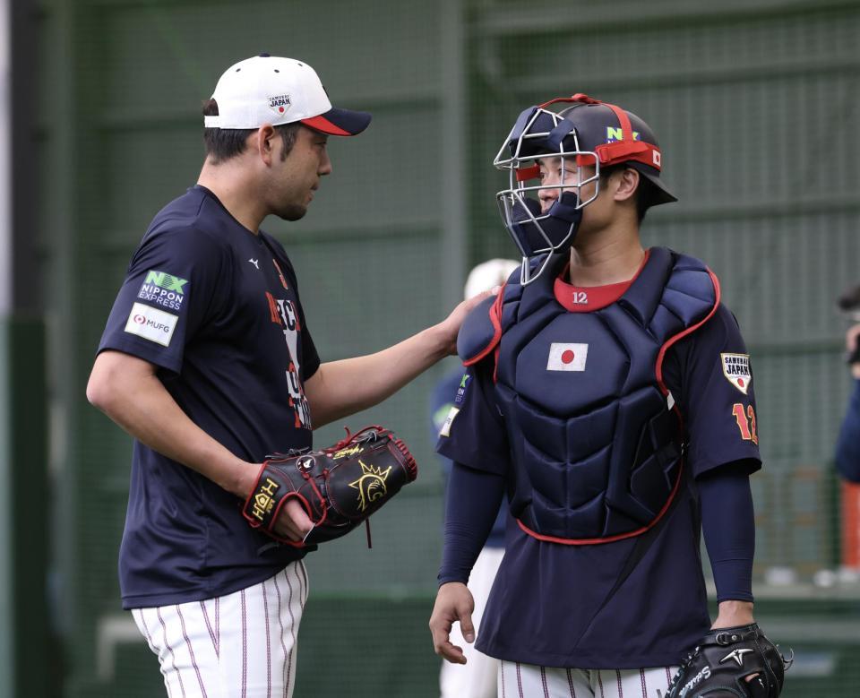 ブルペンでの投球を終え、坂本（右）の肩をポンとたたく菊池（撮影・伊藤笙子）