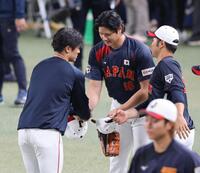 坂本（左）と握手を交わす大谷