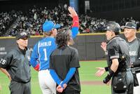 試合前のメンバー表交換でハイタッチをする新庄監督（背番号１）