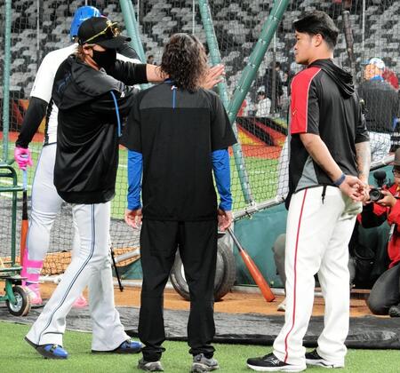 身ぶりを交えながら話す新庄監督（左）と味全・林智勝コーチ（右）