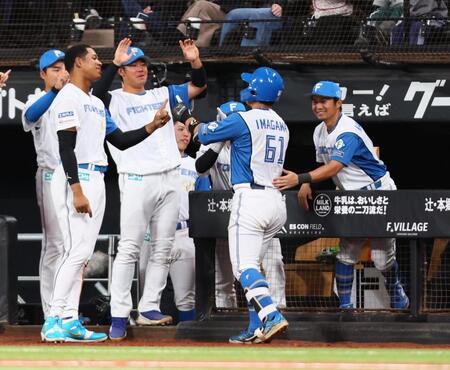 ７回、ソロを放った今川（６１）を迎える日本ハムナイン（撮影・中島達哉）