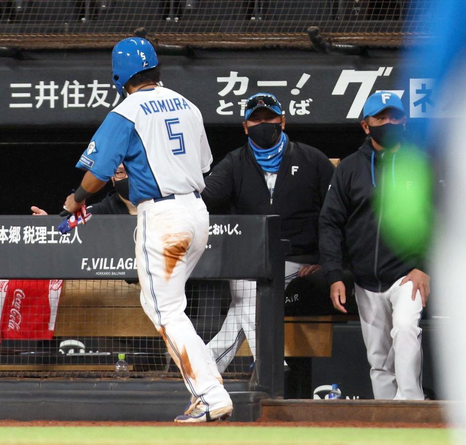 ５回、中島の先制打で生還した野村（５）を迎える新庄監督（中央）＝撮影・中島達哉