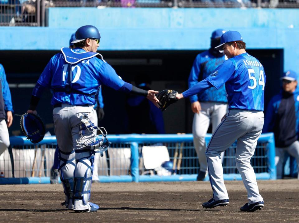 ２回を終え、捕手戸柱とタッチを交わす石田裕