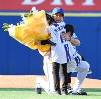 ２人の息子さんから花束を渡され、涙ぐむ三嶋氏（撮影・佐藤厚）